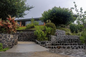 A stone staircase leading to a house with a garden and a view of the sky.