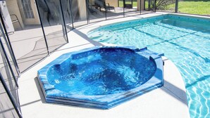 Een zwembad met een jacuzzi, omringd door een overdekt terras.