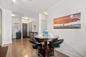 Enjoy a savoury meal at the dining table that comfortably seats four guests. - Downtown 1B + D Condo, Central Location, Parking (Toronto)