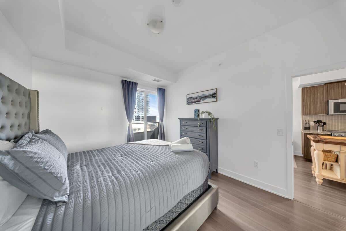 Cozy bedroom with a stylish tufted headboard and mirrored closet doors.