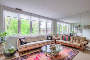 Relax and unwind in the bright, comfy, and spacious living room, perfect for lounging after a day out in the city. - Cozy 2BR Home w/ Workspaces & Parking (Toronto)