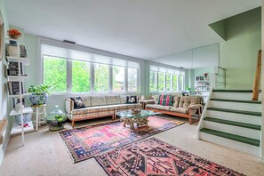 Relax and unwind in the bright, comfy, and spacious living room, perfect for lounging after a day out in the city. - Cozy 2BR Home w/ Workspaces & Parking (Toronto)