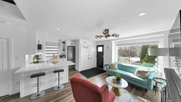 Relax in a cozy living space with plush seating & a 65” Smart TV.