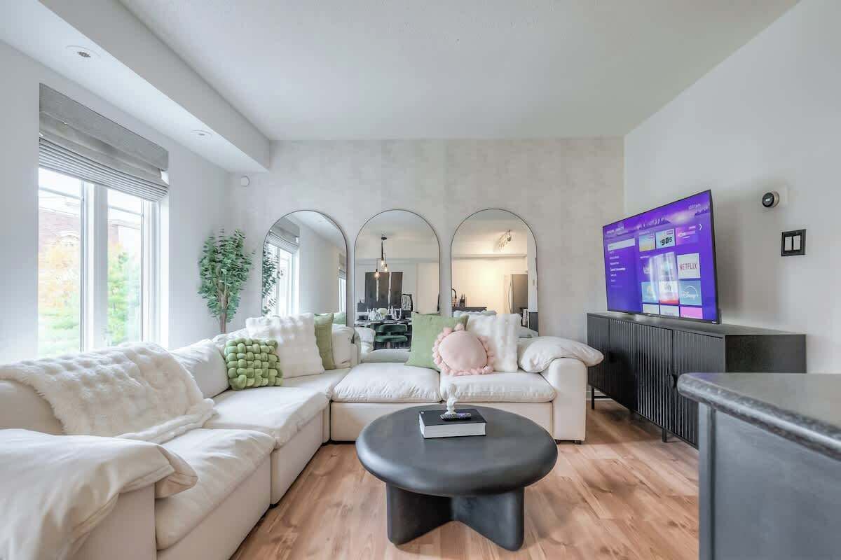 Bright and cozy townhouse living room with comfortable seating and a smart TV.
