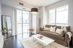 Living room with direct access to a private balcony, perfect for indoor-outdoor relaxation. - Luxury Condo w/ CN Tower View, Workspace (Toronto)