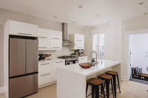 Well-equipped kitchen with sleek finishes, spacious counters, and everything needed for home-style meals. - Toronto Home • 4BR + Private Patio + 2 Parking (Toronto)