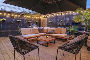Enjoy seasonal gatherings with friends, thanks to cozy seating, ambient lighting, and a large umbrella for shade or shelter. - Toronto Home • 4BR + Private Patio + 2 Parking (Toronto)
