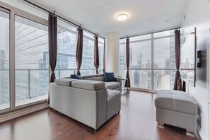 A welcoming area designed for relaxation and entertainment, featuring comfortable seating and a cozy atmosphere. - Modern 2BR City View Retreat w/Balcony & Workspace (Toronto)