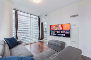 A welcoming area designed for relaxation and entertainment, featuring comfortable seating and a cozy atmosphere. - Modern 2BR City View Retreat w/Balcony & Workspace (Toronto)