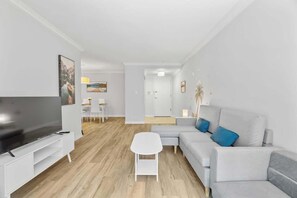 Relax in the cozy living room with a Smart TV, perfect for movie nights or lazy mornings. - Downtown 3BR Condo w/Parking, Walk to Hotspots (Toronto)