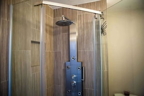 Eine moderne Duschkabine mit Glastür, Brausekopf und Bedienfeld.