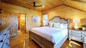 A wooden-paneled bedroom with a bed, dresser, nightstand, and ceiling fan. - Twisted Mane - Prime Location - Family Friendly (Broken Bow)