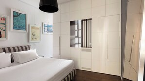 Un dormitorio con cama, armario y ventana con persianas.