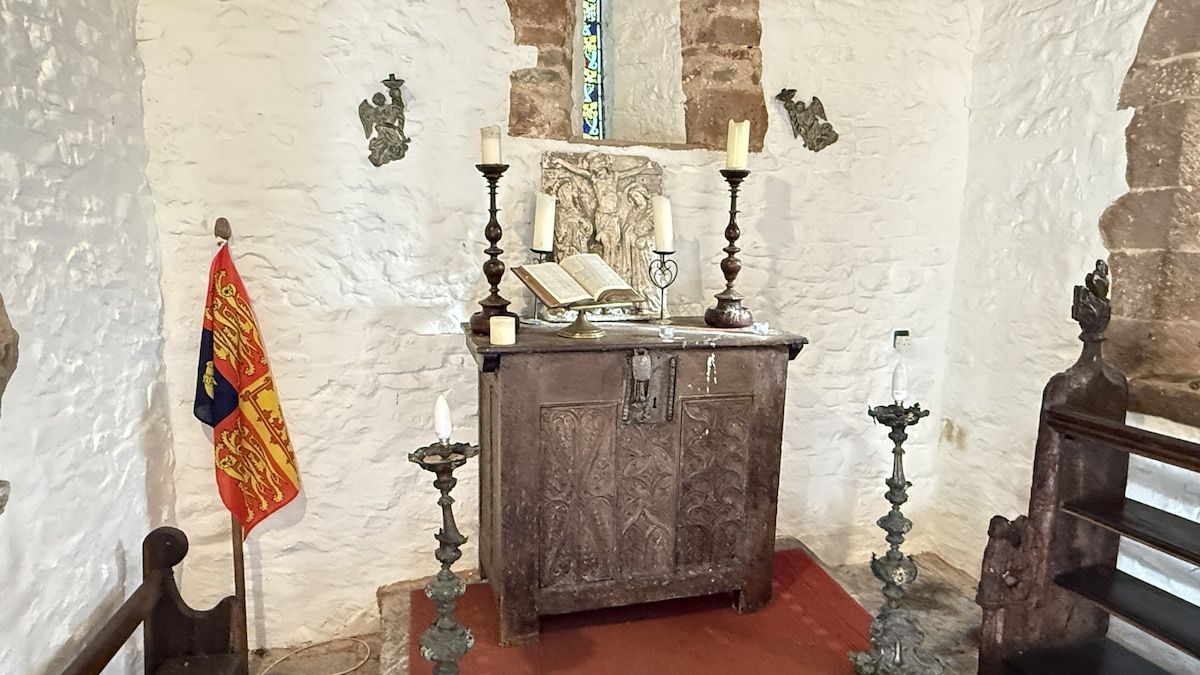 Ein Zimmer mit einem Holzkabinett, einer Flagge und einem religiösen Symbol.