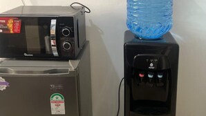 Un erogatore d'acqua e un forno a microonde su un bancone.