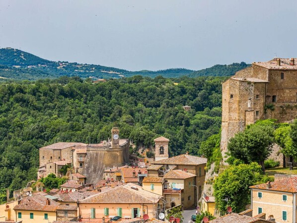 A historic town with stone buildings, a prominent tower, and a castle-like structure.