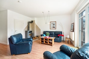 Una sala de estar con sofá, mesa de centro y chimenea.