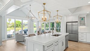 Una cocina amplia con una isla grande, electrodomésticos modernos y vistas al exterior.