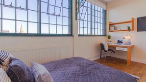 Une chambre à coucher avec un lit, un bureau et une chaise.