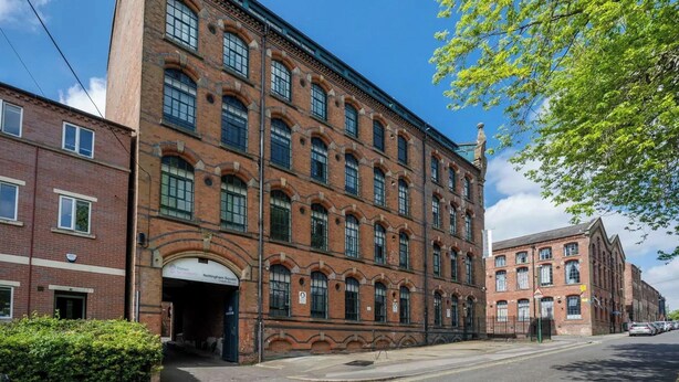 Un bâtiment en briques rouges, doté de fenêtres en arc de cercle et d’une enseigne indiquant « Nottingham Square ».
