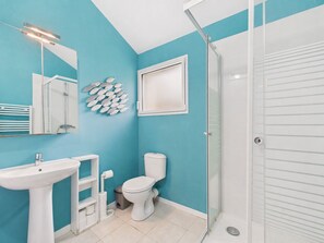 Une salle de bain avec un lavabo, des toilettes et une douche.