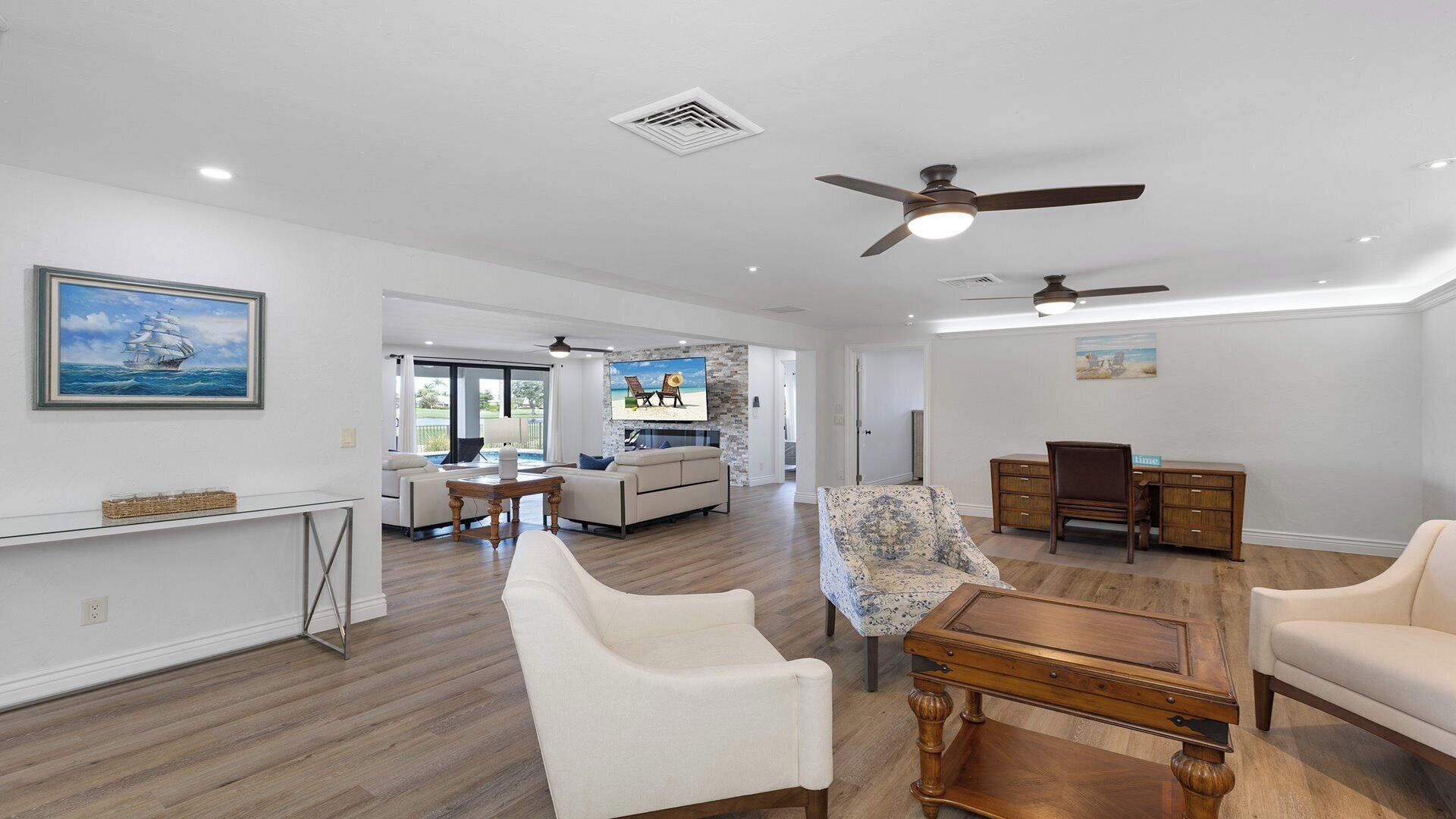 A spacious living area with a fireplace, a dining table, and a kitchen in the background.
