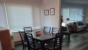 A dining area with a table and chairs, a ceiling fan, and a sofa in the background. - Lake front cottage with private dock
4 Bedroom  2 bathroom (Innisfil)