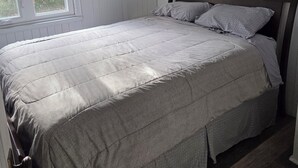 A bedroom with a bed, a window, a ceiling fan, and a painting on the wall. - Lake front cottage with private dock
4 Bedroom  2 bathroom (Innisfil)