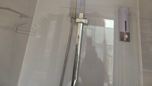 A modern shower with a square head and multiple nozzles, a control panel, and a handrail. - Cosy 1 Bedroom Flat Near Balham Station (London)
