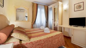Ein Hotelzimmer mit Bett, Fernseher, Spiegel und einer Tür zu einem anderen Raum.