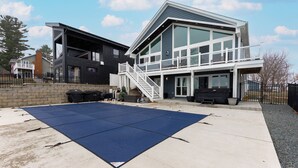 Een modern huis met twee verdiepingen en een overdekte patio.