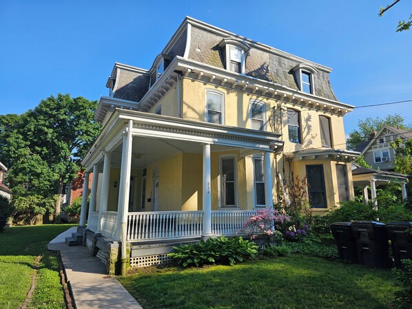 A two-story house with a porch, columns, and a number '220' on the front.