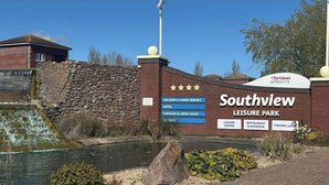 Een gebouw van baksteen met een bord voor Southview Leisure Park, waarop faciliteiten staan aangegeven zoals een hotel, recreatiecentrum, restaurant en een podiumbar.