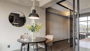 A modern interior with a round table, two chairs, a hanging pendant light, a vase with plants, and a large mirror on the wall. - w* | Tasteful 1BR w/ Private Balcony in Tabacalera (Ciudad de México)
