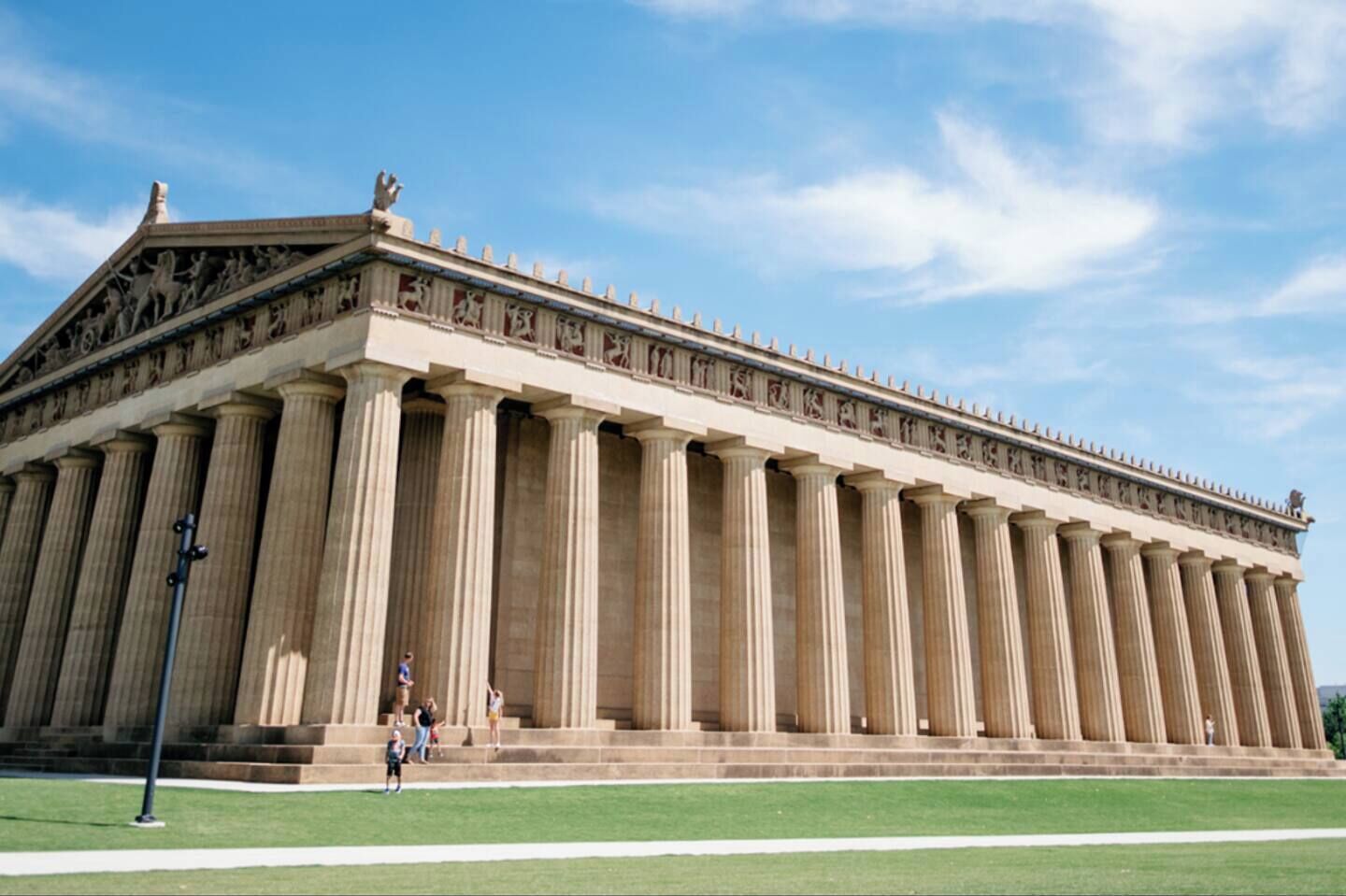A large classical building with a long facade, tall columns, and detailed sculptures.