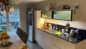 Ett modernt kök med kylskåp, diskho och matplats.