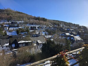 A residential area with houses, some with snow on roofs, and a hill in the background. - Apartment 'Sauerland 3' with Mountain View and Wi-Fi (Willingen (Upland))