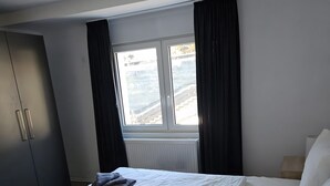 A hotel room with two beds, a wardrobe, a window with curtains, and a radiator. - Apartment 'Sauerland 3' with Mountain View and Wi-Fi (Willingen (Upland))