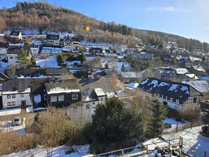 A residential area with houses, some with snow on roofs, and a hill in the background. - Apartment 'Sauerland 3' with Mountain View and Wi-Fi (Willingen (Upland))