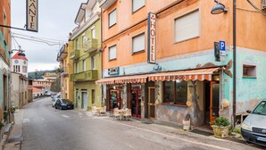 A street with a hotel, a restaurant, and parked cars. - Double Room 205 with Air Conditioning (Jerzu)