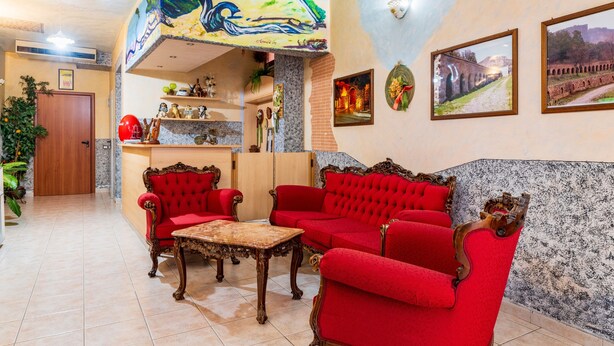 A lobby with red sofas, a marble coffee table, and a mural on the ceiling. - Double Room 205 with Air Conditioning (Jerzu)