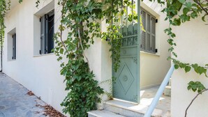 A building with a stone staircase, a green door, and a window with shutters. - Timeless 1 bedroom Luxury at Panathenaic Stadium (Athina)
