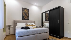 Um quarto moderno com uma cama, uma mesa de cabeceira, um guarda-roupa e obras de arte na parede.