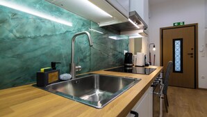 A modern kitchen with a stainless steel sink, wooden countertop, and a green marble backsplash. - Timeless 1 bedroom Luxury at Panathenaic Stadium (Athina)