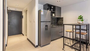 Eine moderne Küche mit einem Edelstahl-Kühlschrank, einer Kaffeemaschine und einer Marmorarbeitsplatte.