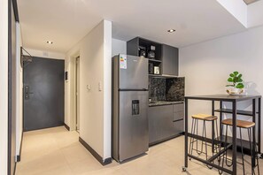 A modern kitchen with a stainless steel refrigerator, a coffee maker, and a marble countertop. - Soho Village en Palermo by Magno | 601 (Buenos Aires)