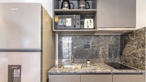 Eine moderne Küche mit einem PHILCO-Kühlschrank, einem Wasserspender, einer Mikrowelle und einem Toaster.