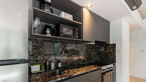Eine moderne Küche mit Marmorarbeitsplatte, eingebauten Geräten und einem eleganten Design.