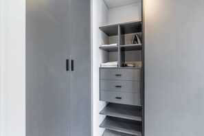 A modern closet with open shelves, drawers, and a hanging rod. - Soho Village en Palermo by Magno | 404 (Buenos Aires)