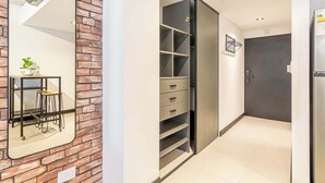 Een modern interieur met een bakstenen muur, een spiegelwand, een inloopkast met schuifdeuren en een keukenhoek.